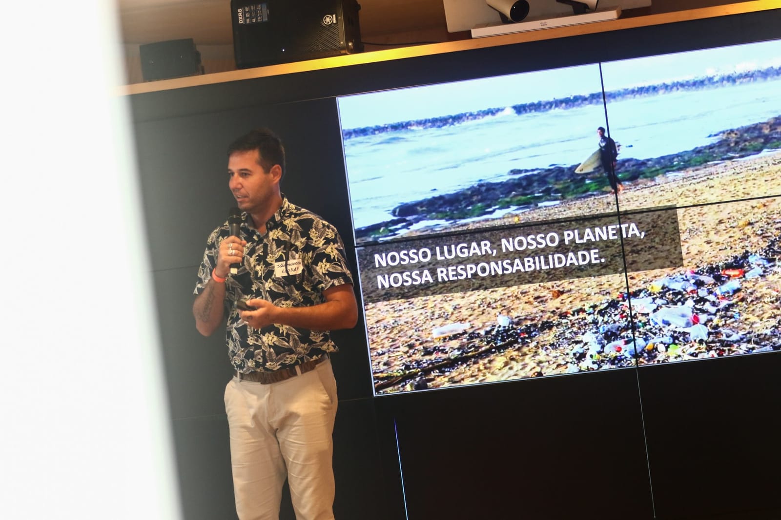 Palestra do Ecosurf com a frase Nosso lugar, nosso planeta, nossa responsabilidade projetada no telão