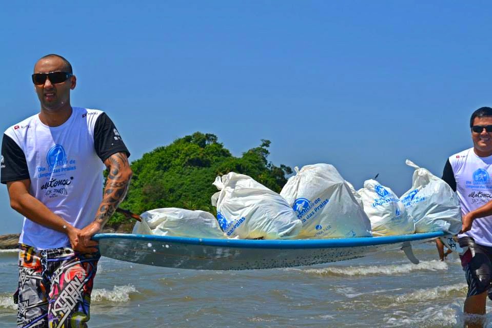 Voluntário Ecosurf com sacos de resíduos em barco