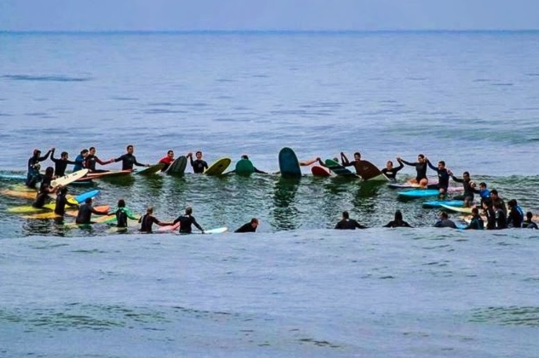 Surfistas em círculo no mar