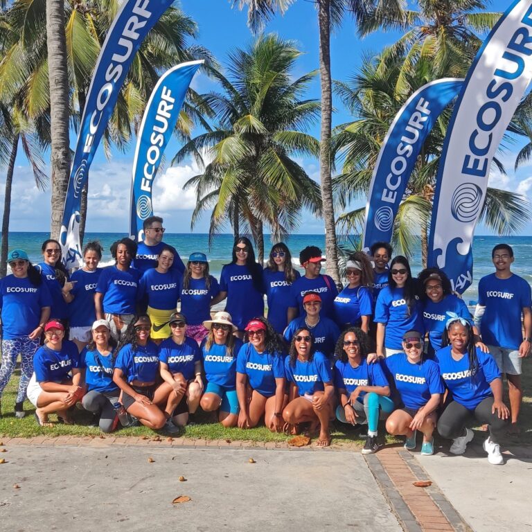 Equipe e voluntários do Ecosurf posam diante das bandeiras do Instituto