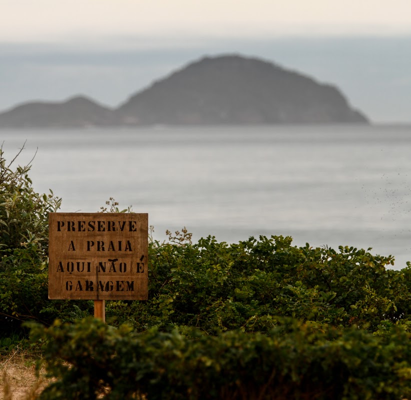 Placa em área costeira pedindo a preservação da praia