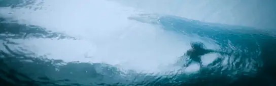 Surfista dentro do tubo visto de baixo da água