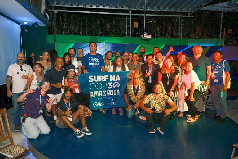Participantes da iniciativa Surf na COP30 Amazônia reunidos com faixa