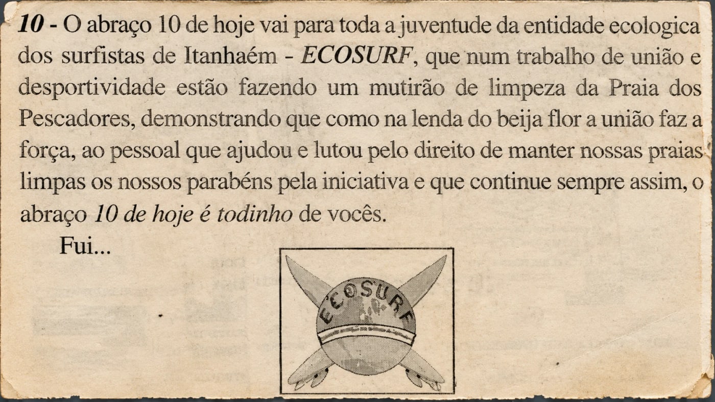 Recorte de jornal com nota sobre o mutirão de limpeza da Praia dos Pescadores e o primeiro símbolo do Ecosurf