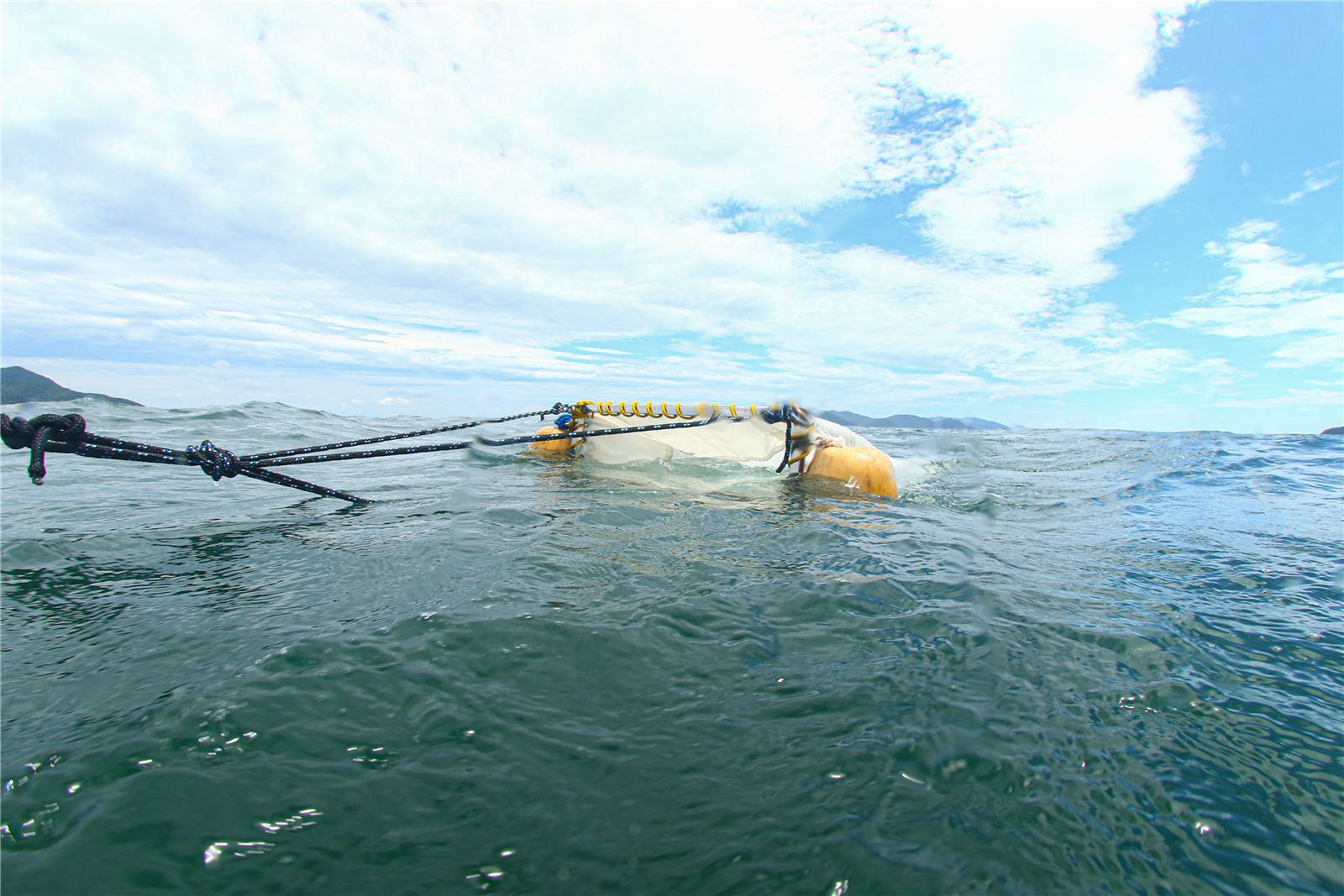 Rede de coleta de microplásticos sendo rebocada na superfície do mar