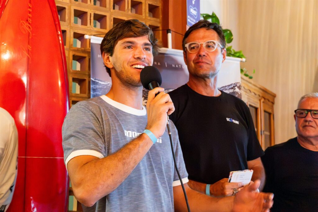 Gabriel Benetton, campeão mundial de kitewave, fala ao microfone na Noite do Surf, em Itanhaém