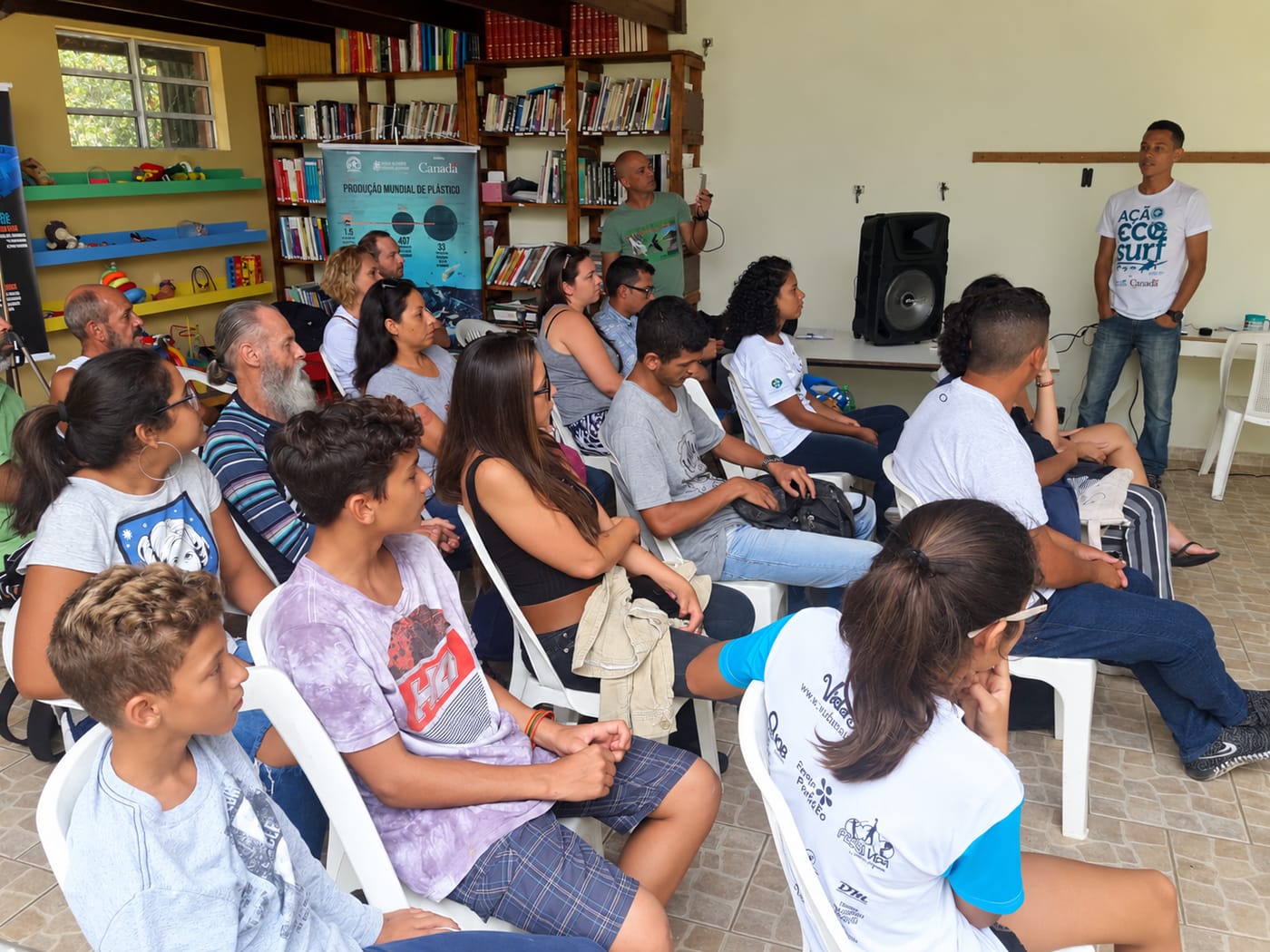 Público acompanha apresentação em sala com biblioteca