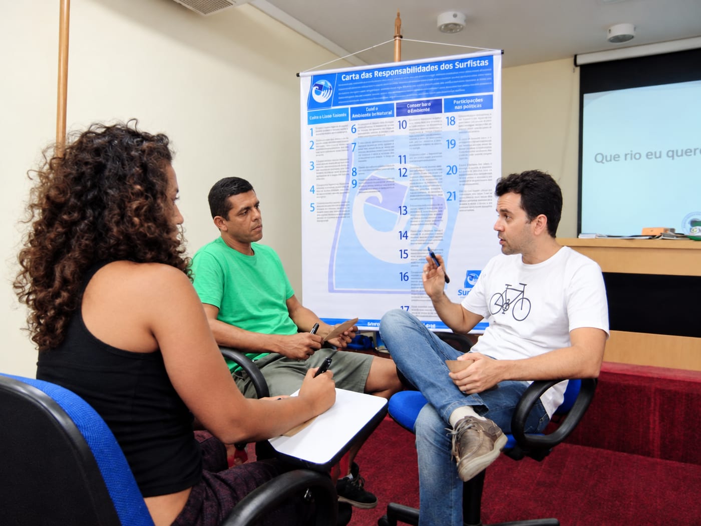 Conversa em grupo diante do banner da Carta das Responsabilidades dos Surfistas